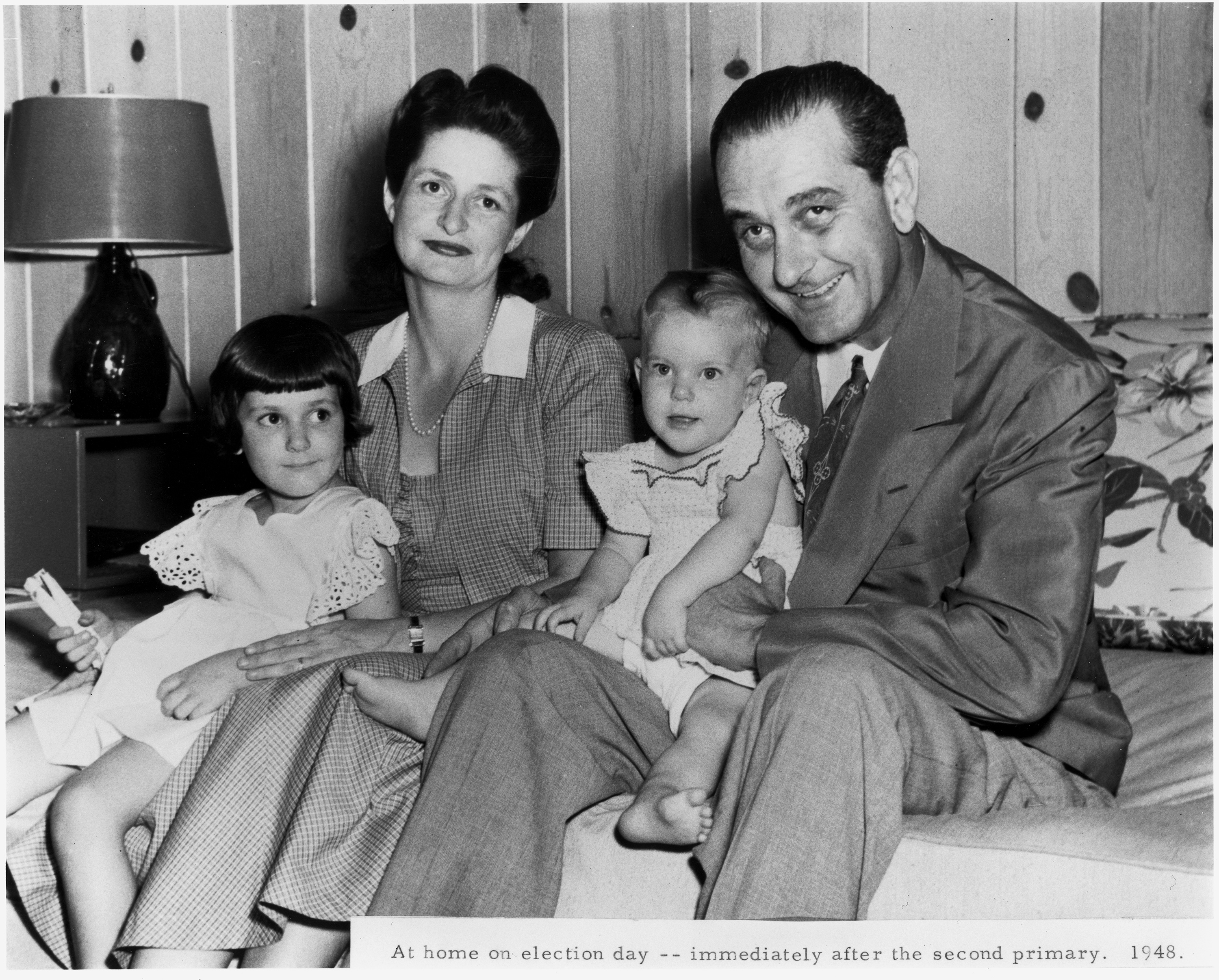 Lady Bird and Lyndon Johnson sit on a sofa with their two small girls, Lynda and Luci.